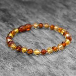 Brățară din chihlimbar baltic cu mărgele semirotunde galbene și maro