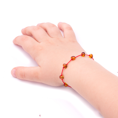 bratara chihlimbar maro cu snur rosu pe mana bebelus