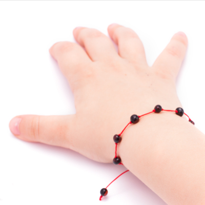 bratara chihlimbar negru cu snur rosu pe mana bebelus