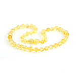 colier bebe chihlimbar baltic galbe, nuanta lamaie, textura lucioasa prezentat pe fundal alb. Remediu natural pentru eruptiile dentare la bebelusi