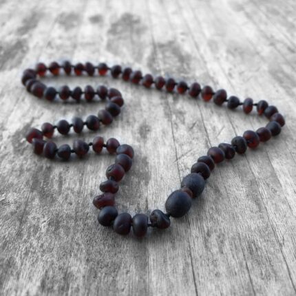 colier ubisex chihlimbar negru mat pe fundal din lemn