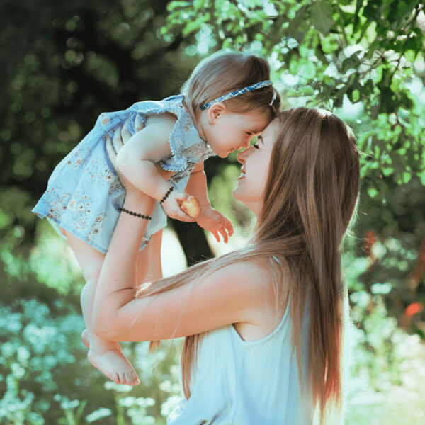 mama si fiica purtand un set de bratri din chihlimbar baltic model cires pentru somn dentitie si imunitate