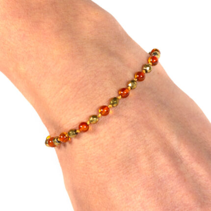 bratara din chihlimbar maro si pietre de hematit auriu prezentata pe mana