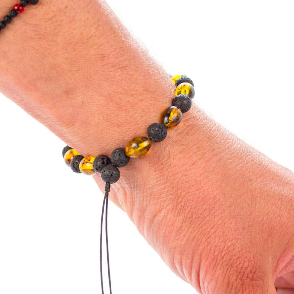 "Brățară din chihlimbar și lavă vulcanică purtată la încheietura mâinii, evidențiind designul natural și ajustabilitatea șnurului