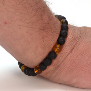 bratara elastica pentru barbati din chihlimbar si onix prezentata pe mana de barbat