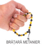Brățară terapeutică din chihlimbar și pietre de lavă, ținută în mână, evidențiind mărimea și textura mărgelelor si faptul ca poate fi folosita pentru rostirea afirmatiilor