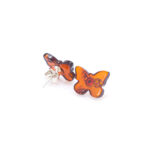 Imagine pe fundal alb cu o pereche de cercei din argint cu chihlimbar, model fluture, culoare coniac