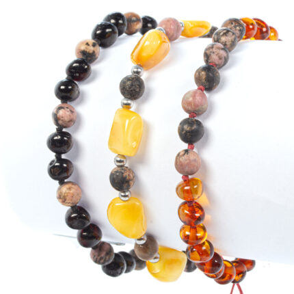 3 bratari din chihlimbar baltic si rodonit pe fundal alb